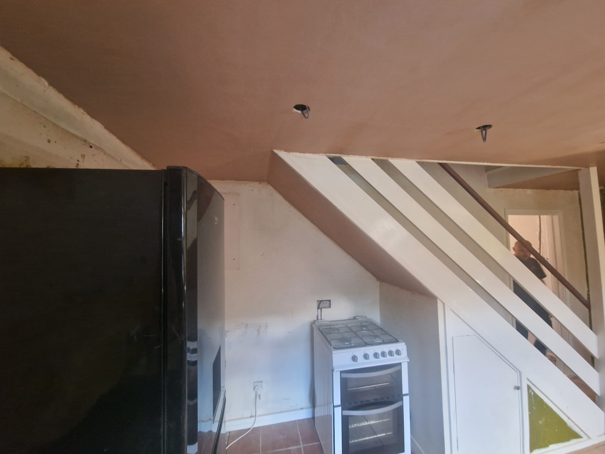 Kitchen with a freshly plastered ceiling above the cooker and staircase