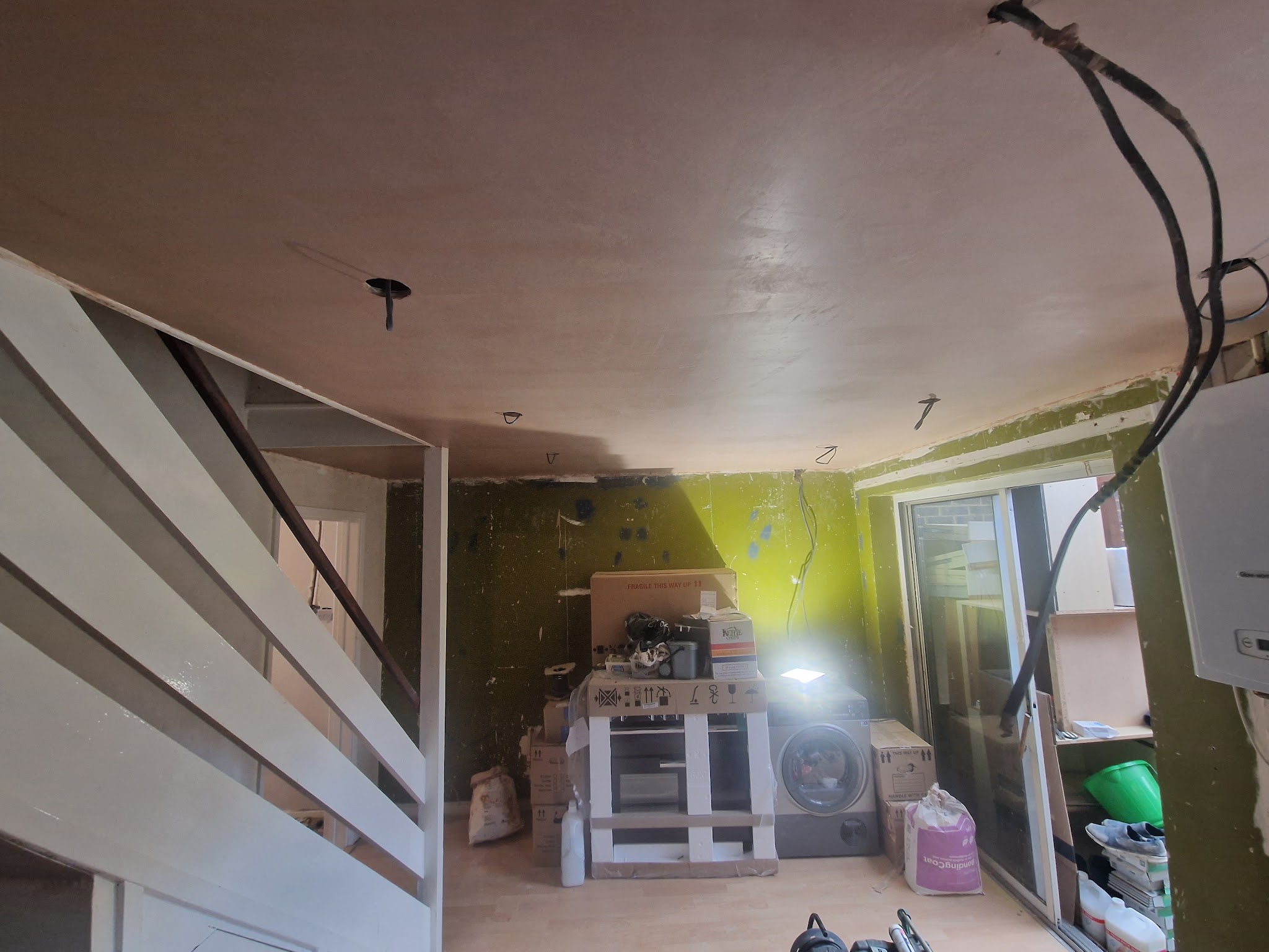 Kitchen mid-job with a newly plastered ceiling