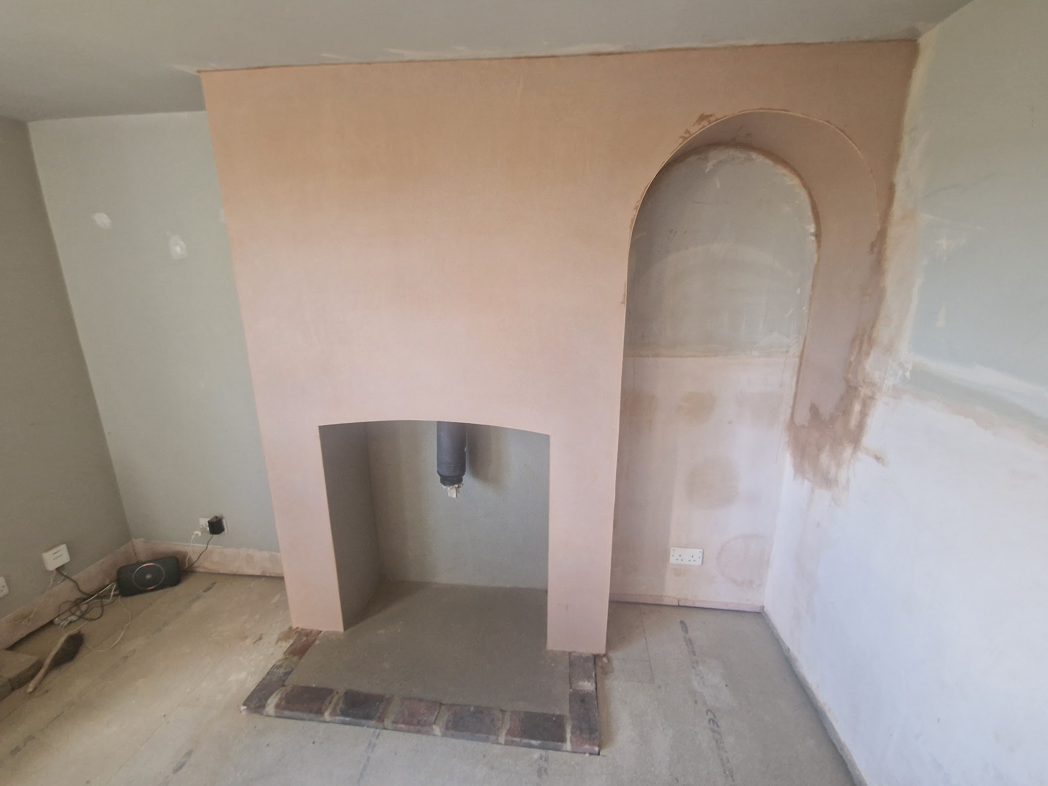 Chimney breast with an arched alcove, freshly plastered
